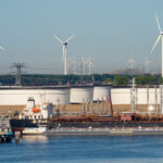 Photo: Wind turbines against the backdrop of oil storage tanks in the Maas River estuary, Rotterdam, Netherlands