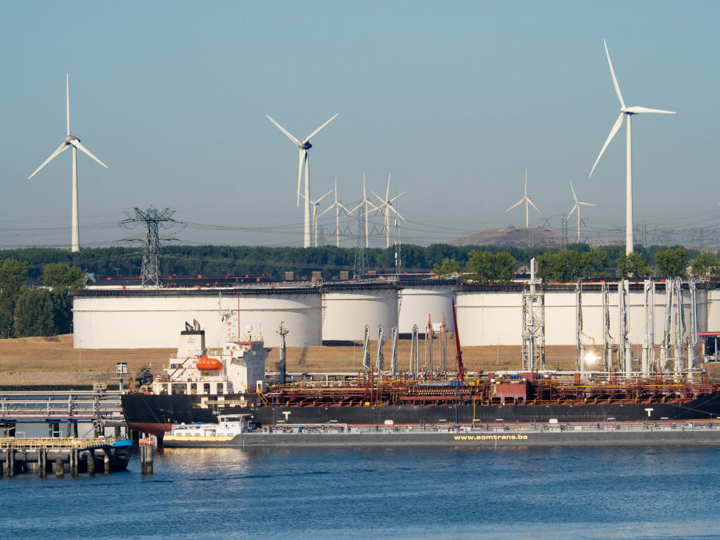 Photo: Wind turbines against the backdrop of oil storage tanks in the Maas River estuary, Rotterdam, Netherlands