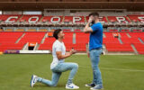 Photo: Adelaide United Player Engages with Partner on Football Field